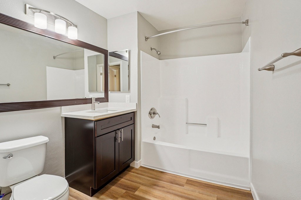 A white bathroom with a white toilet, a sink, and a bathtub.