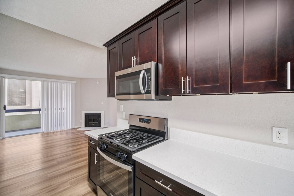 A kitchen with dark wood cabinets and a white countertop.