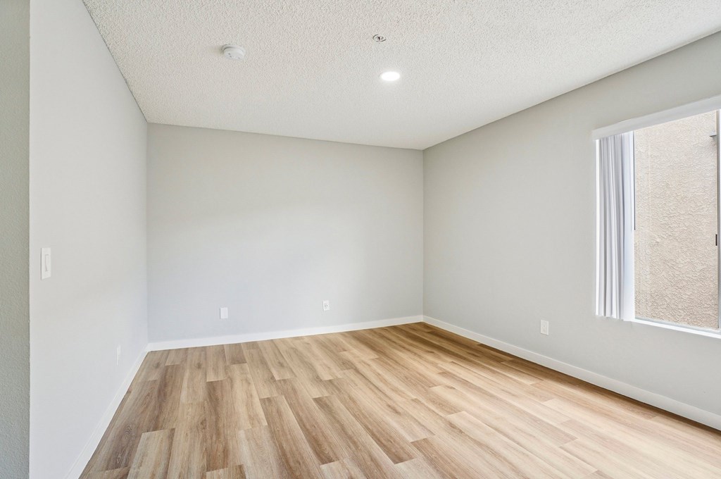 A room with wooden flooring and a window.