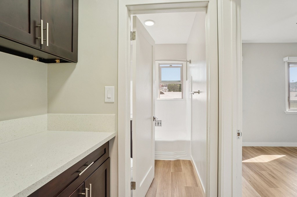 A hallway with a white door leading to a bedroom.