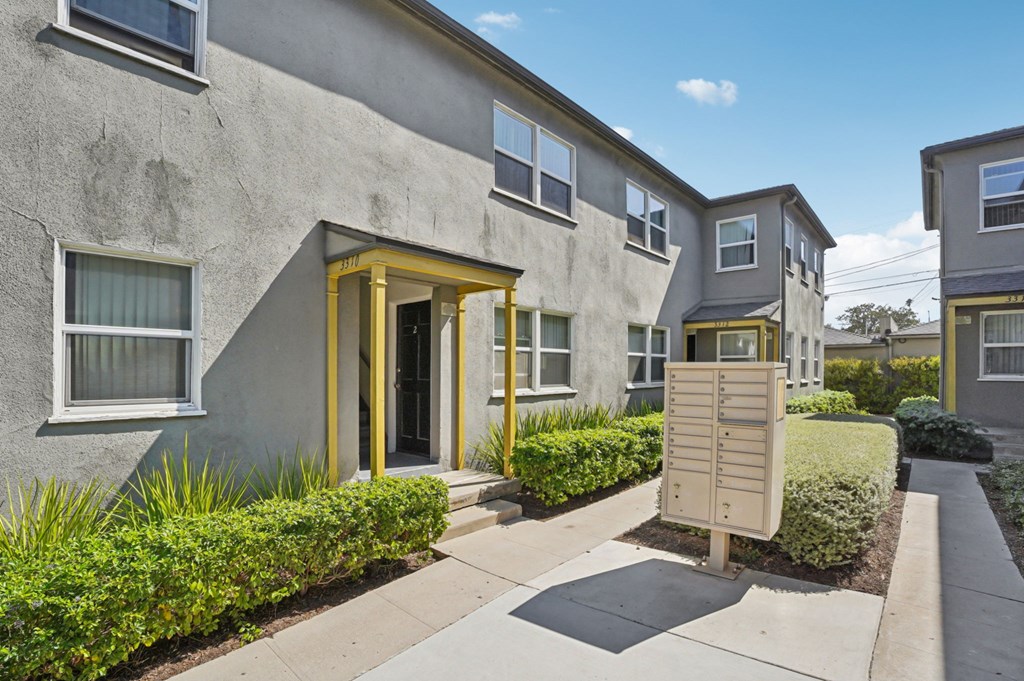 A building with a yellow door and windows with white frames.
