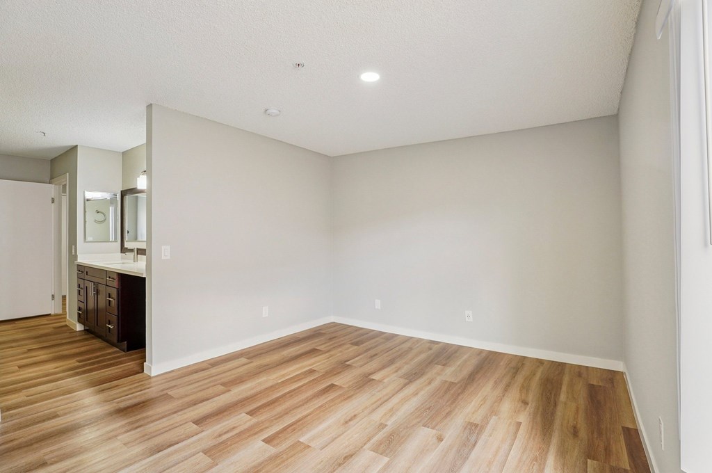 A room with wooden flooring and white walls.