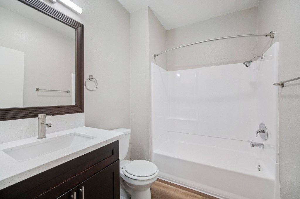 A white bathroom with a toilet, sink, and bathtub.