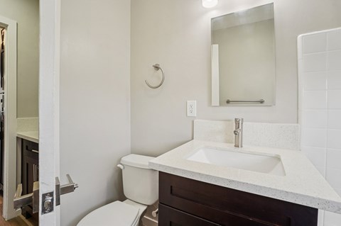 A white sink with a silver faucet and a white toilet in a bathroom.