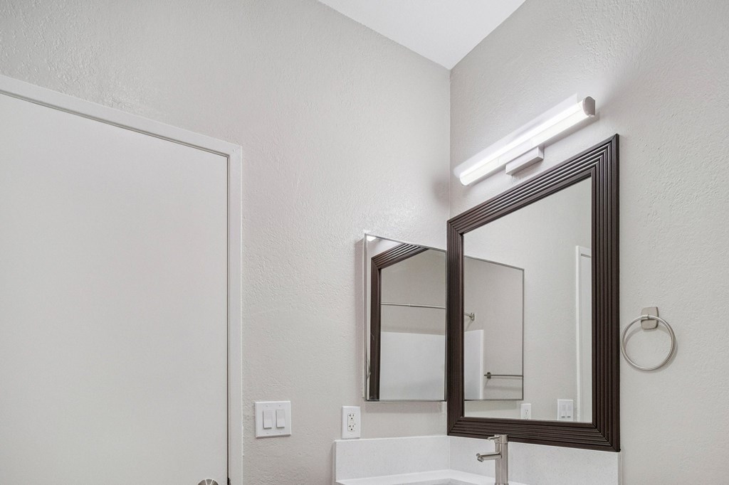 A bathroom with a white sink and a mirror.