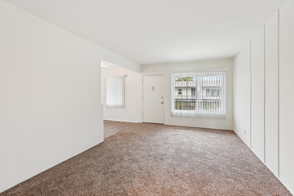 A room with brown carpet and white walls.