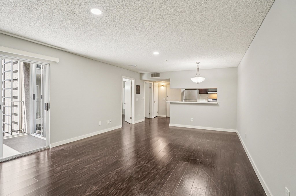 A spacious room with wooden floors and white walls.