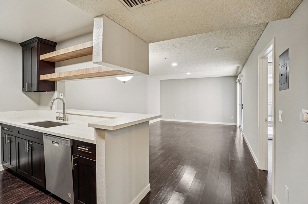 A kitchen with dark wood cabinets and a white counter top.
