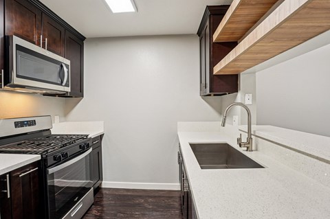 A modern kitchen with a stainless steel oven and microwave.