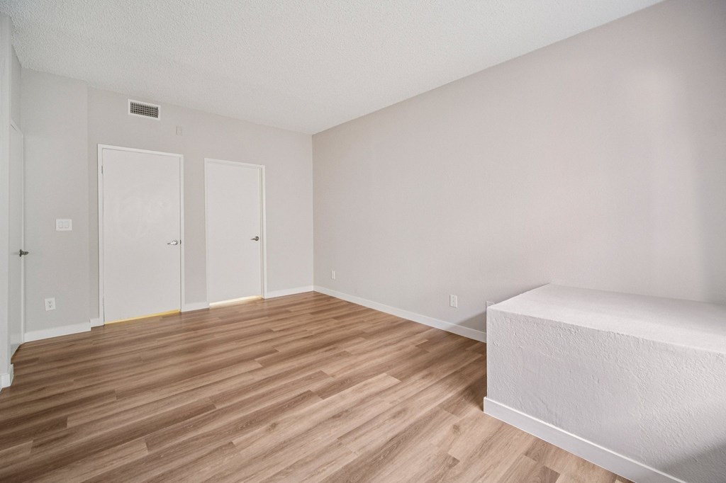 A room with two doors and a bed.