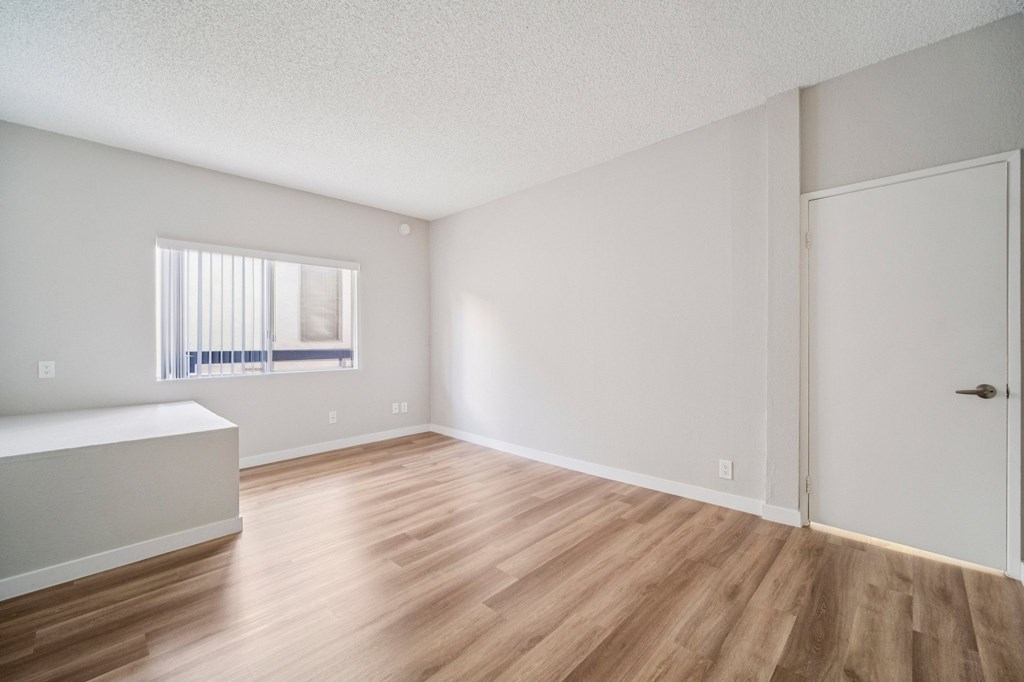 A room with wooden flooring and white walls.