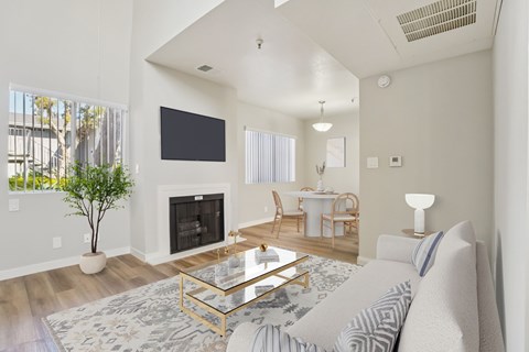 A living room with a fireplace and a television on the wall.