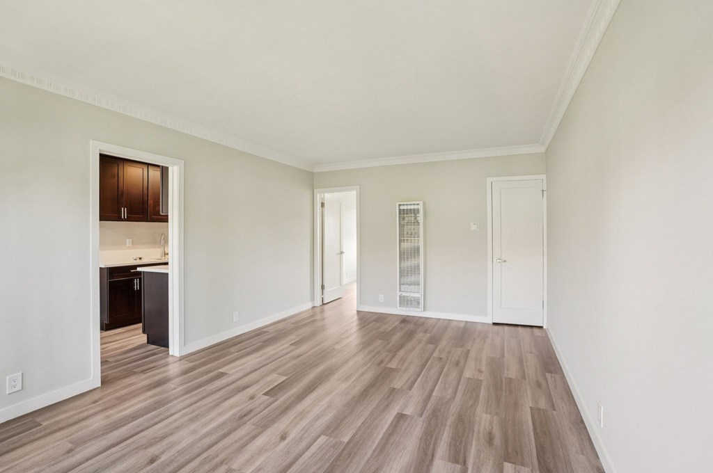A room with wooden flooring and white walls.