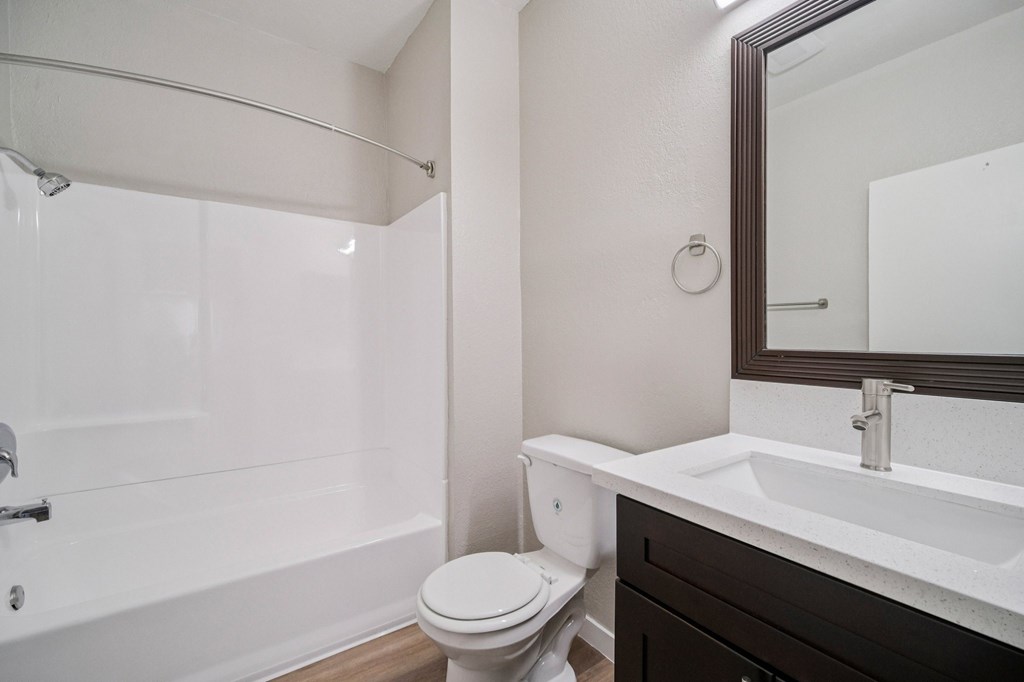 A white toilet sits next to a white sink in a bathroom.