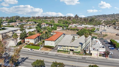 A view of a road with cars and buildings on the side.