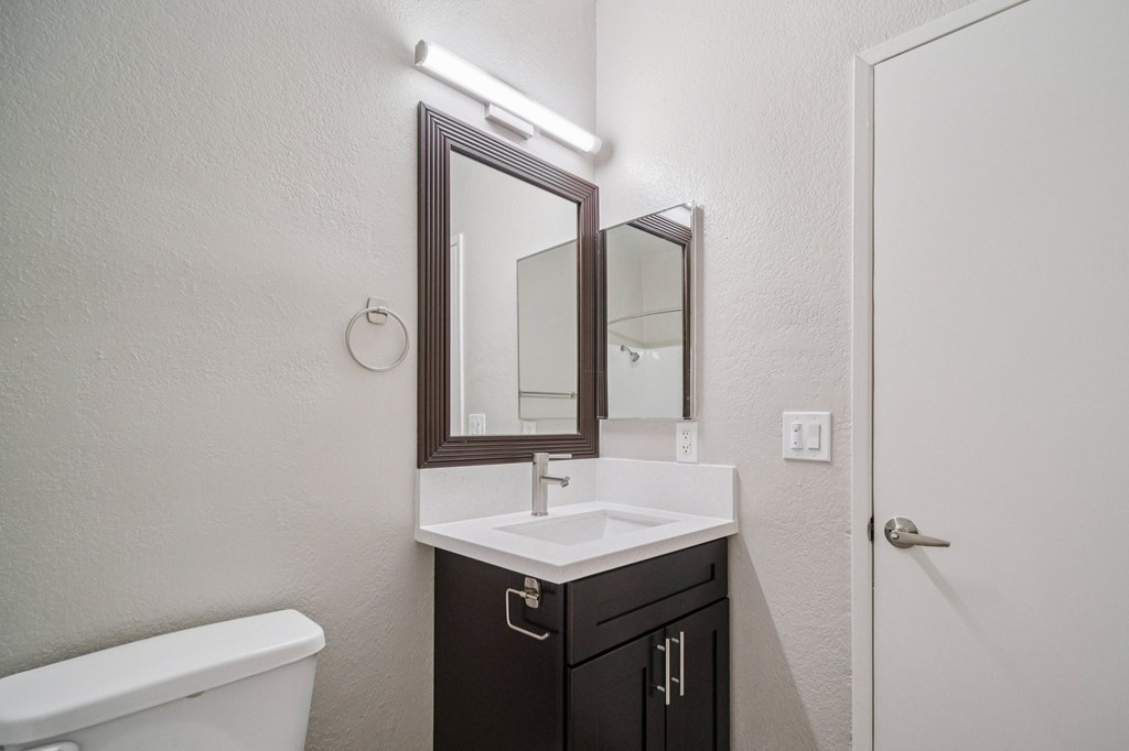A bathroom with a white sink and a white toilet.