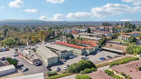 A view of a parking lot with cars and buildings.