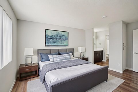 A bedroom with a large bed and a painting on the wall.