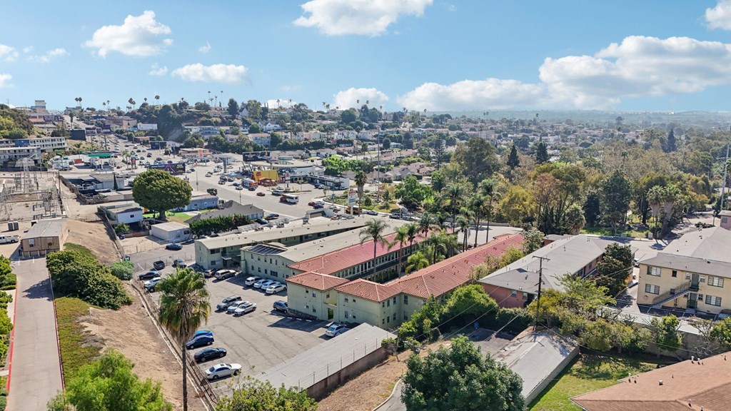 A sunny day in a residential area with houses and parked cars.