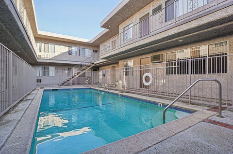 A swimming pool in a courtyard surrounded by buildings.
