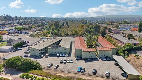 A parking lot with cars and a building in the background.