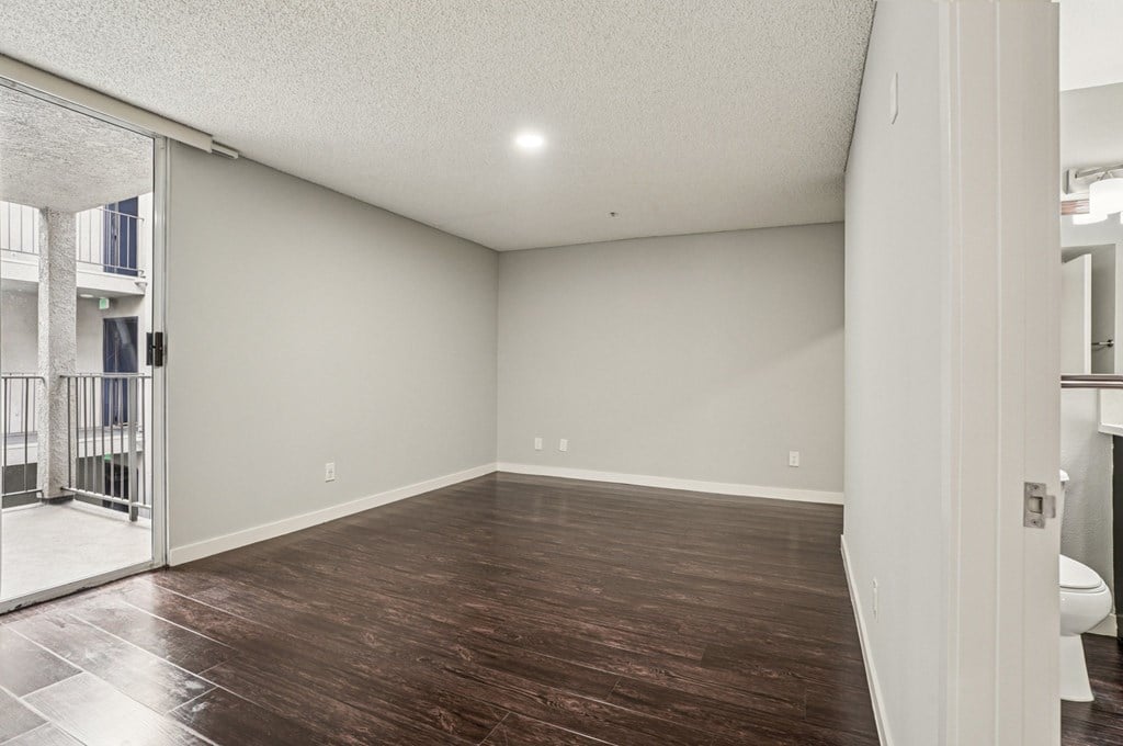 A room with wooden flooring and white walls.