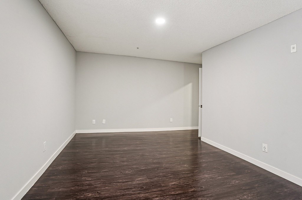 A room with wooden flooring and white walls.