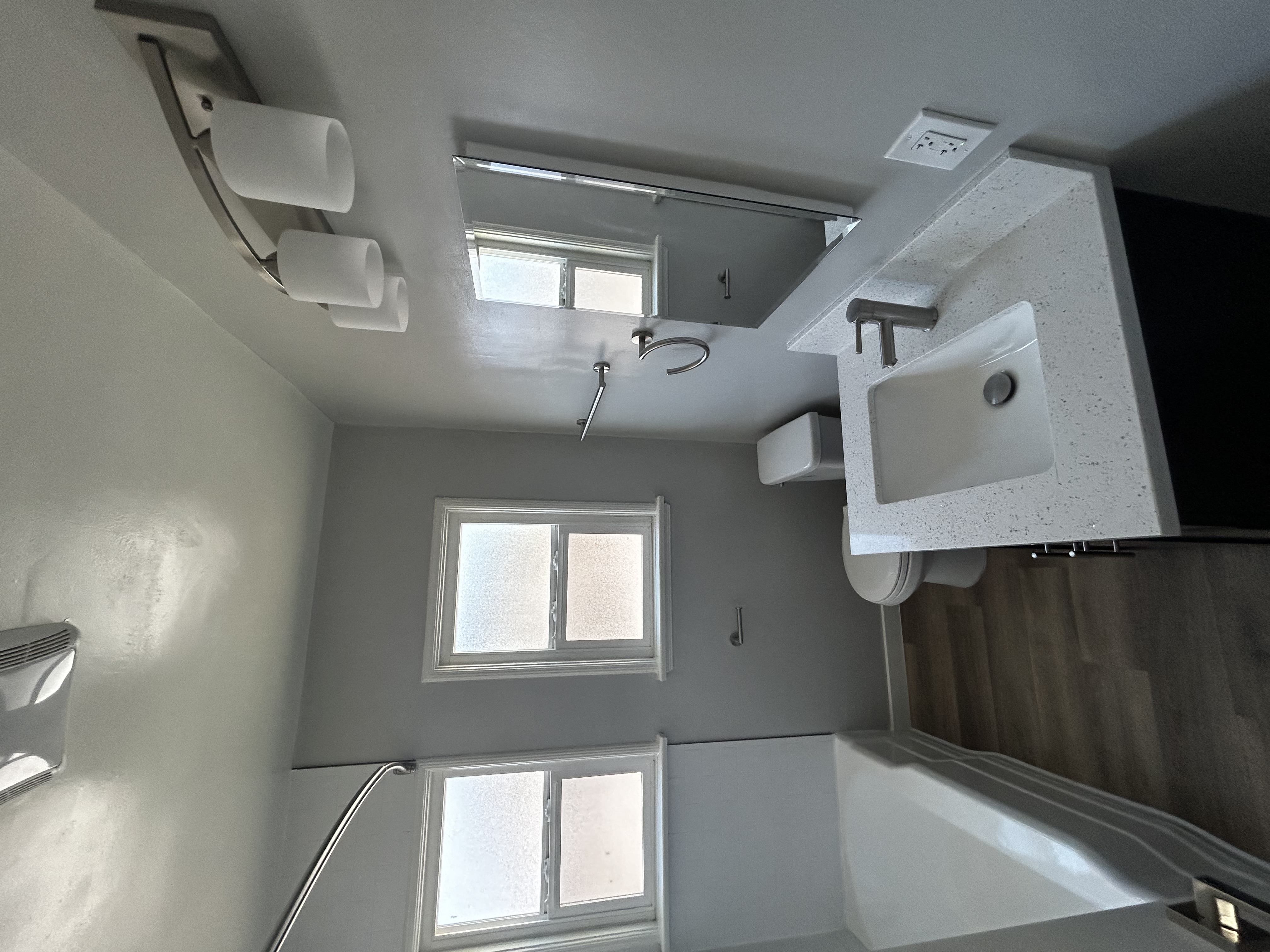 a bathroom with a sink and a mirror and a window