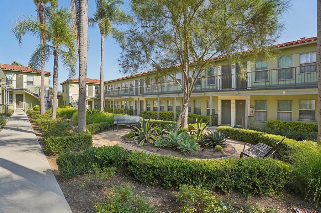 A sunny day at a residential complex with a well-maintained garden in the foreground.
