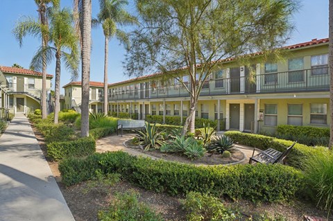 A sunny day at a residential complex with a well-maintained garden in the foreground.
