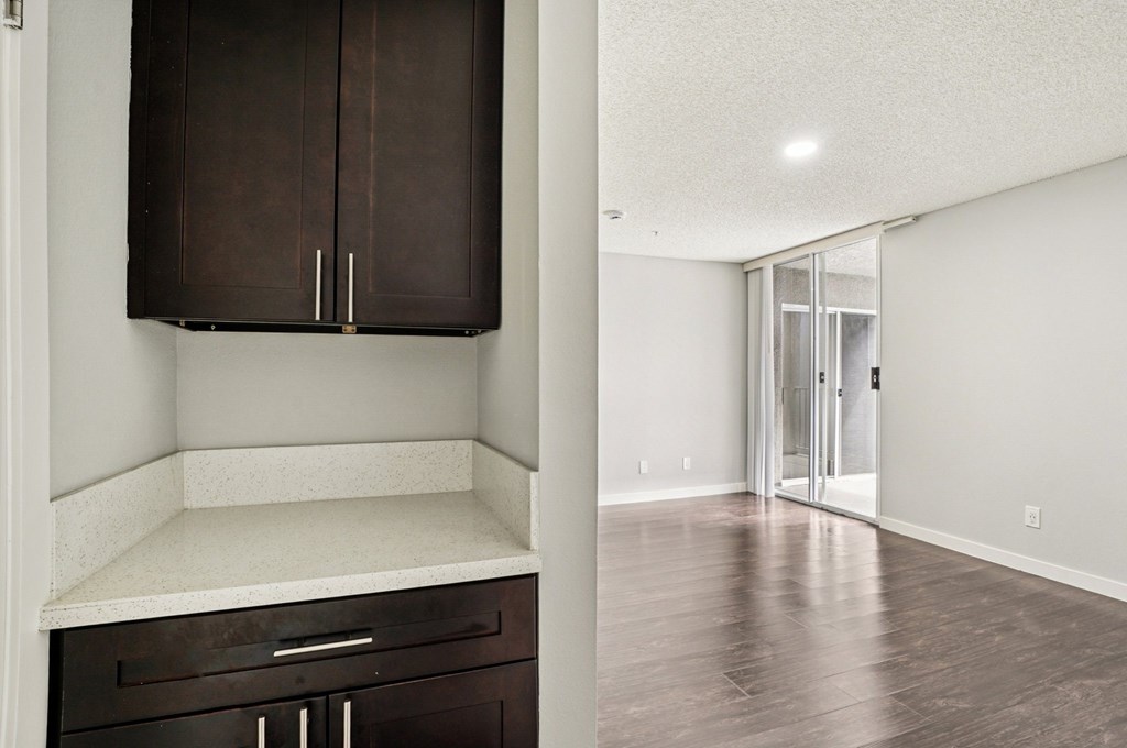 A kitchen with dark brown cabinets and a white countertop.