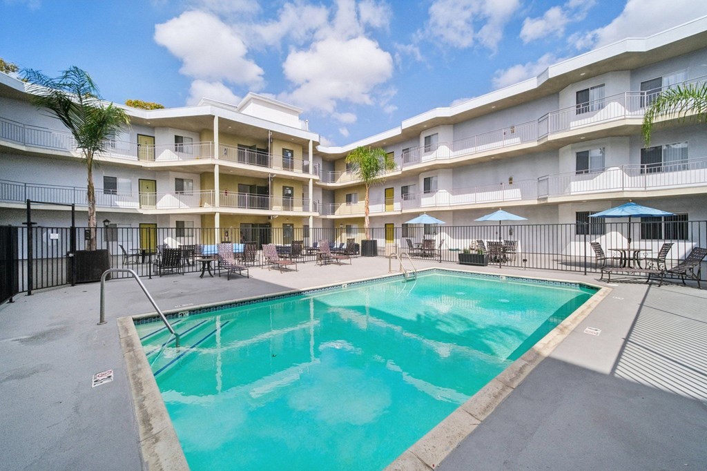 A swimming pool in a courtyard surrounded by apartment buildings.