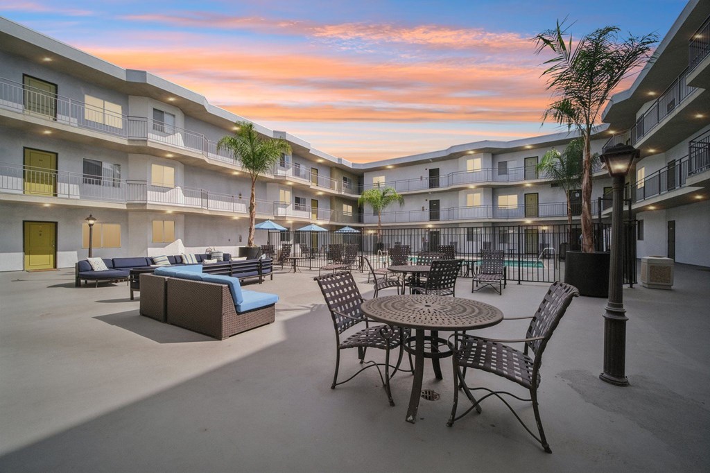 A courtyard with a table and chairs surrounded by apartment buildings.