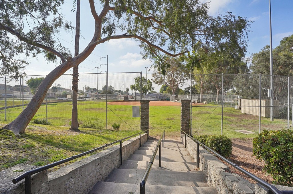 A staircase with a metal railing leads up to a gate.