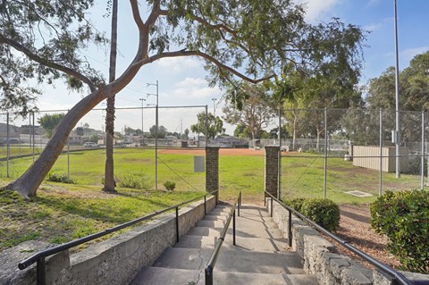 A staircase with a metal railing leads up to a gate.