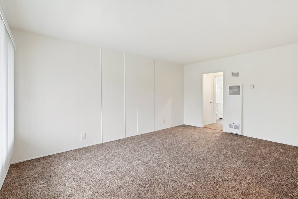 A room with white walls and carpeted floor.