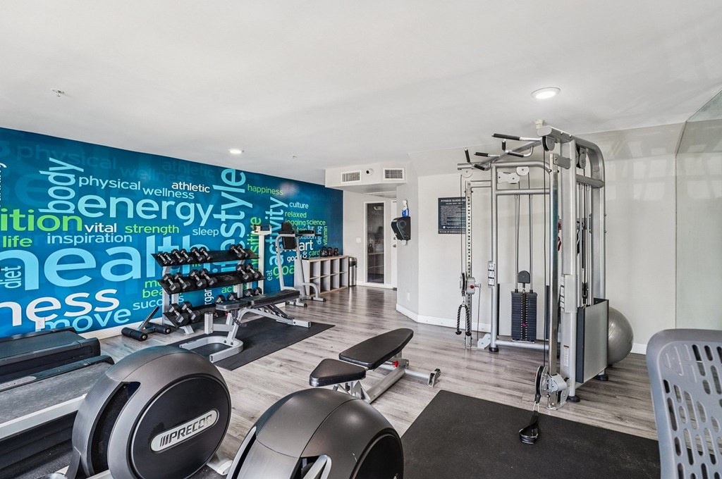 A gym with a wall of words related to fitness and exercise.