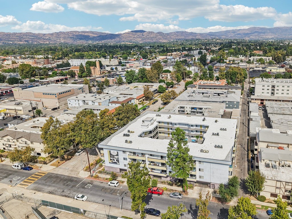 A cityscape with buildings and cars under a blue sky.