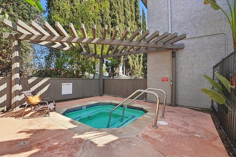 A small pool with a wooden pergola over it.