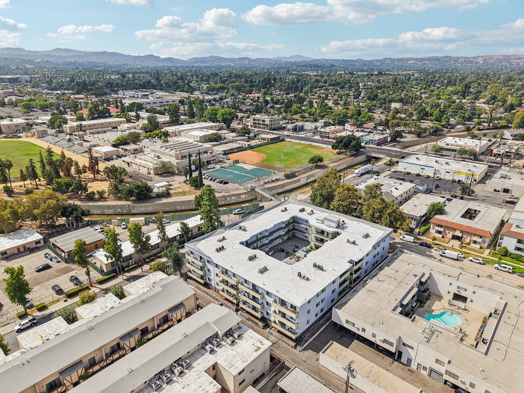A view of a city with buildings, a pool, and a field.