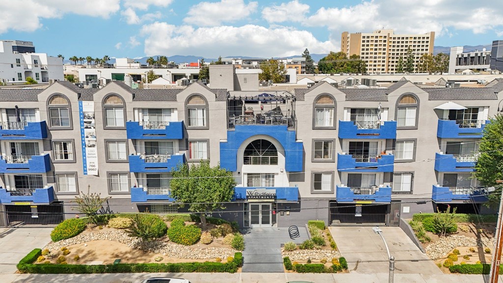 A blue and white apartment complex with a courtyard in the middle.