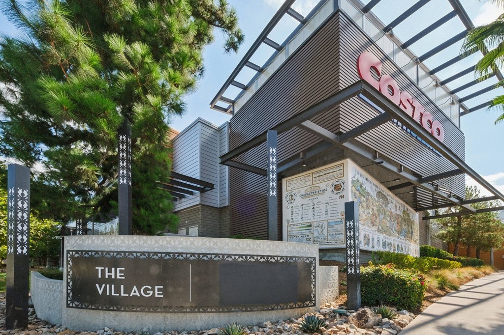 A sign that says "The Village" is in front of a Costco store.