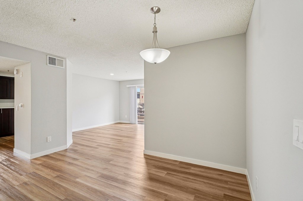 A room with wooden floors and a hanging light fixture.
