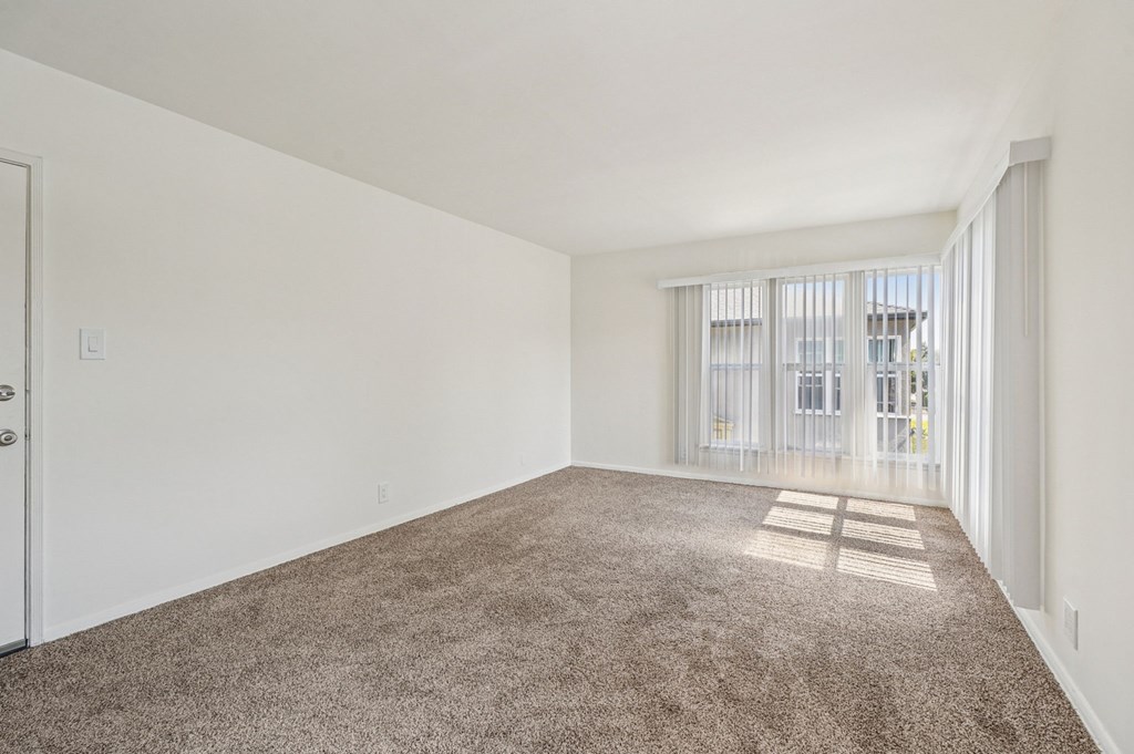 A room with a carpeted floor and a door.