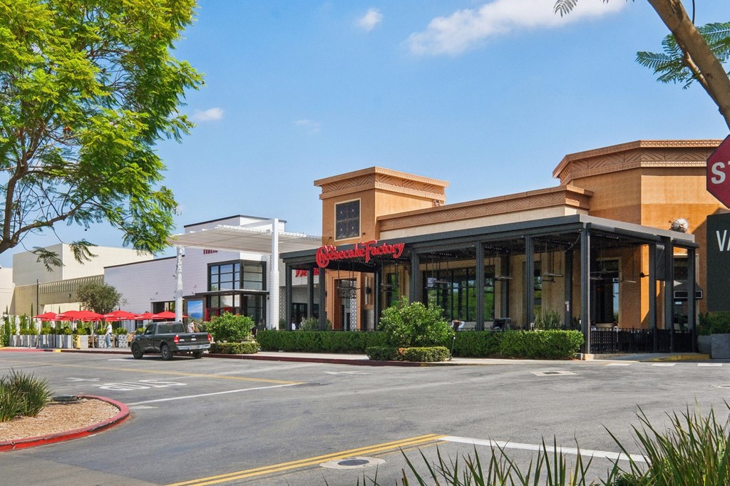 A street view of a shopping area with a red stop sign.