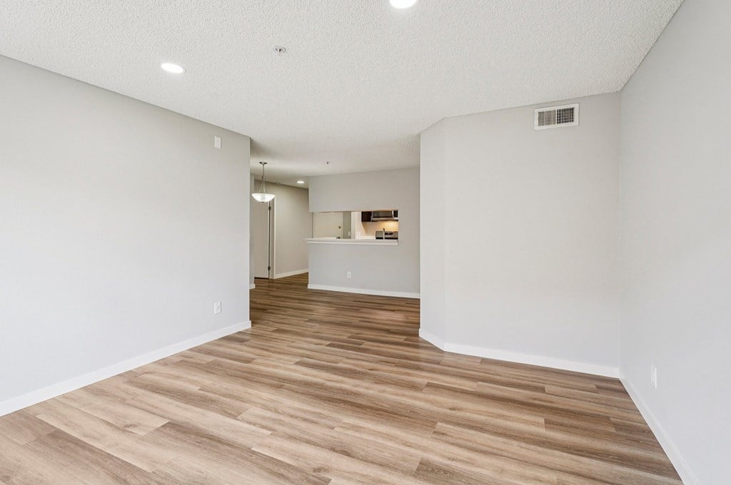 A room with wooden flooring and white walls.