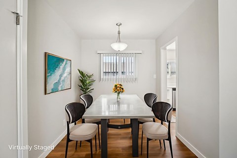 A dining room with a table and chairs.