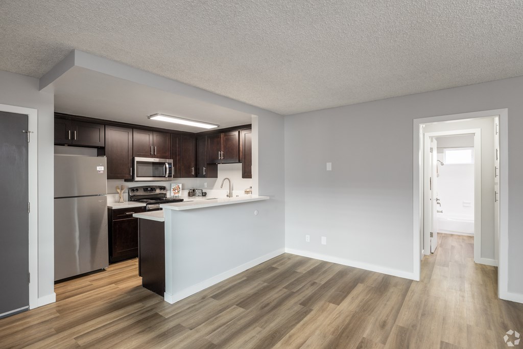 A kitchen with wooden floors and white walls.