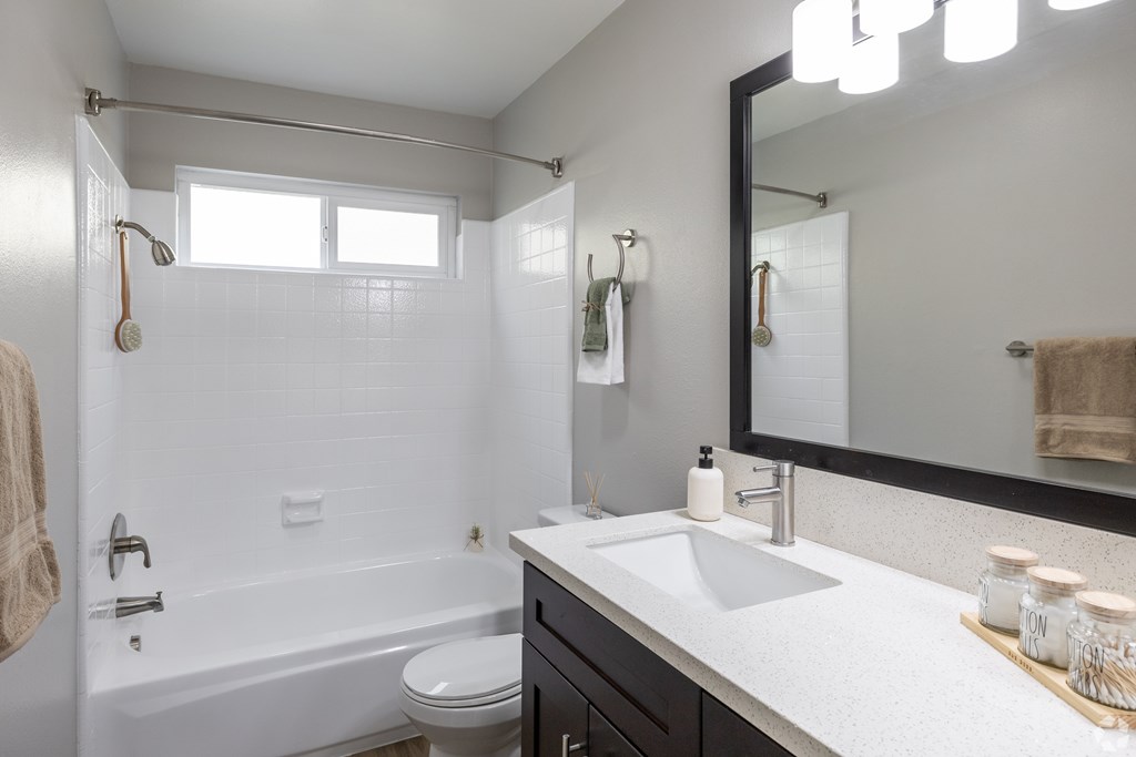 A white bathroom with a white tub and sink.