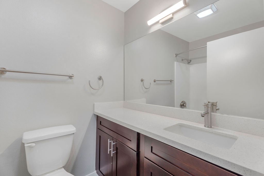 A white toilet sits next to a sink in a bathroom.
